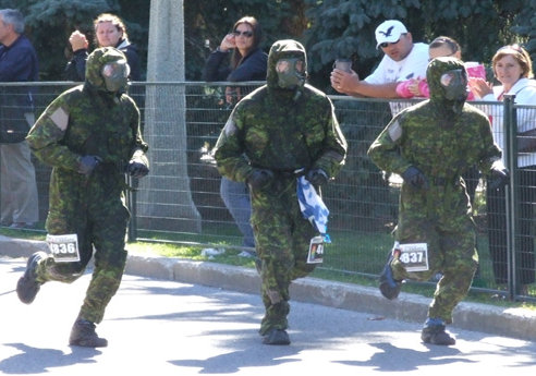 3.	The three RMC Saint-Jean officer cadets wearing the CBRN breathing apparatus during the half marathon. / Trois élèves-officiers du CMR Saint-Jean portant un masque CBRN pendant le demi marathon.  